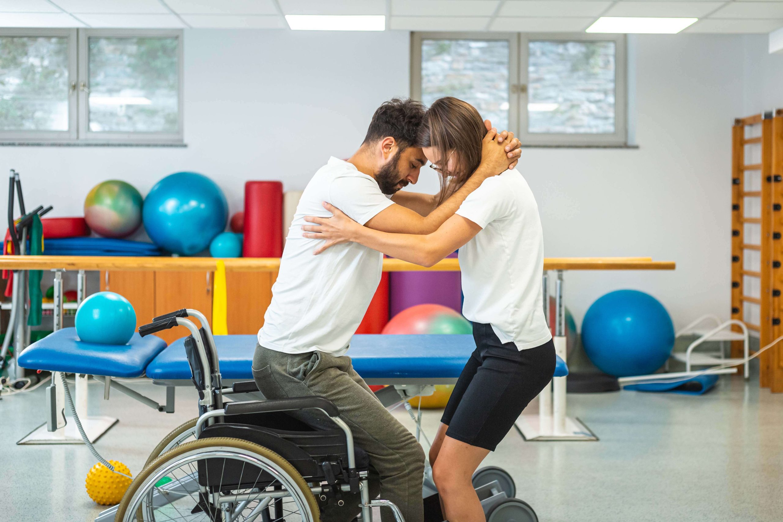 Man with a nursing staff trying to stand from wheelchair
